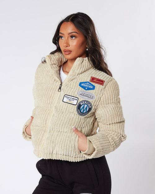 Veste femme cordon beige et badge.